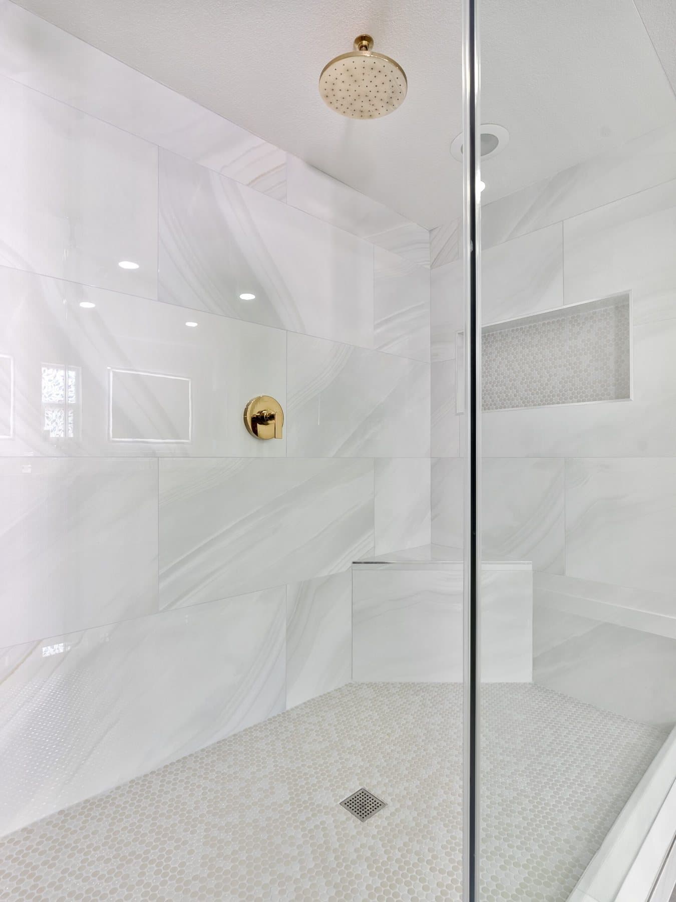 Lone Mountain bathroom remodel: rain-head fixture behind frameless glass