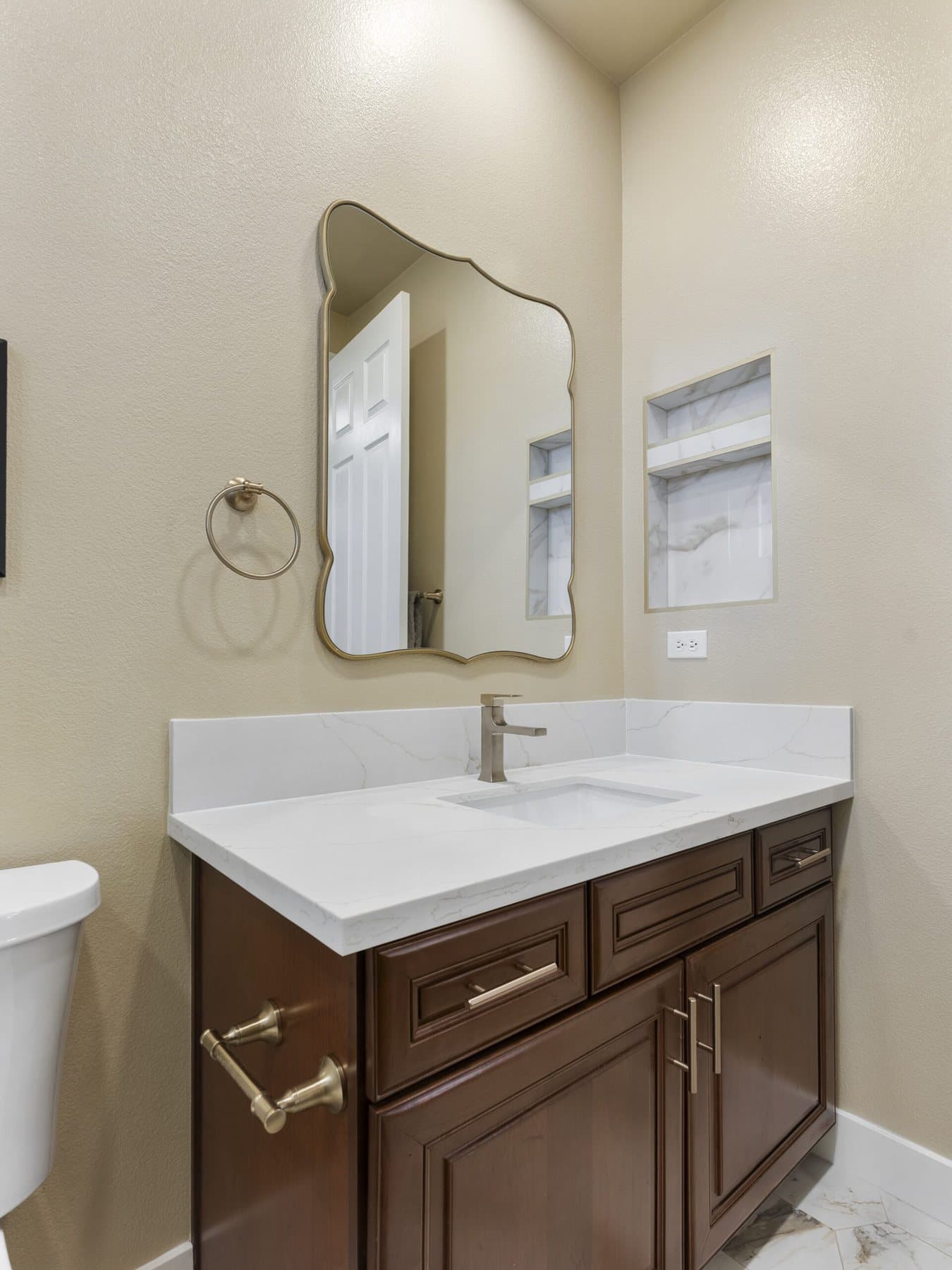 Small bathroom remodel: vanity with white countertop and arched mirror