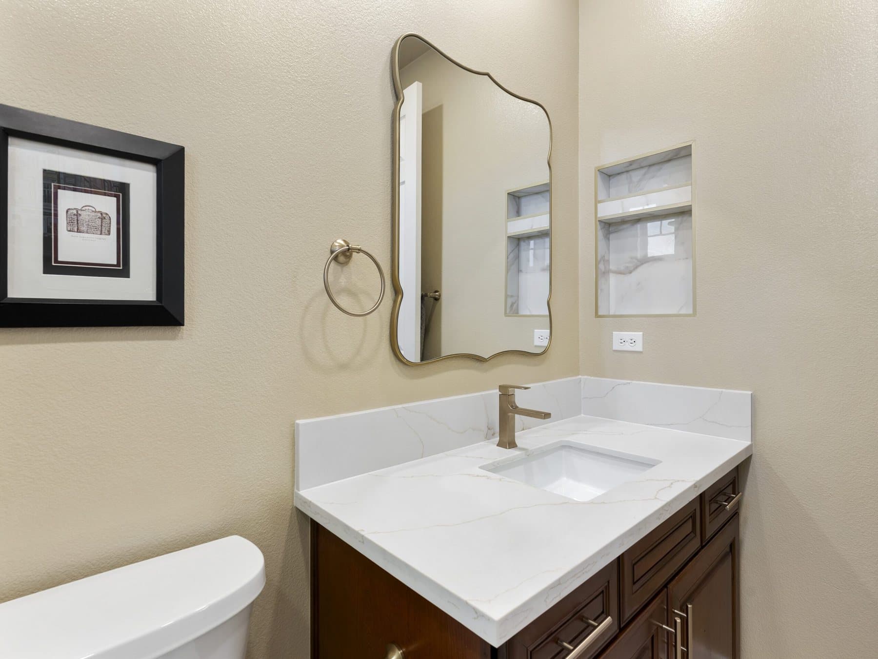 Small bathroom remodel: vanity with arched mirror and brushed-gold faucet