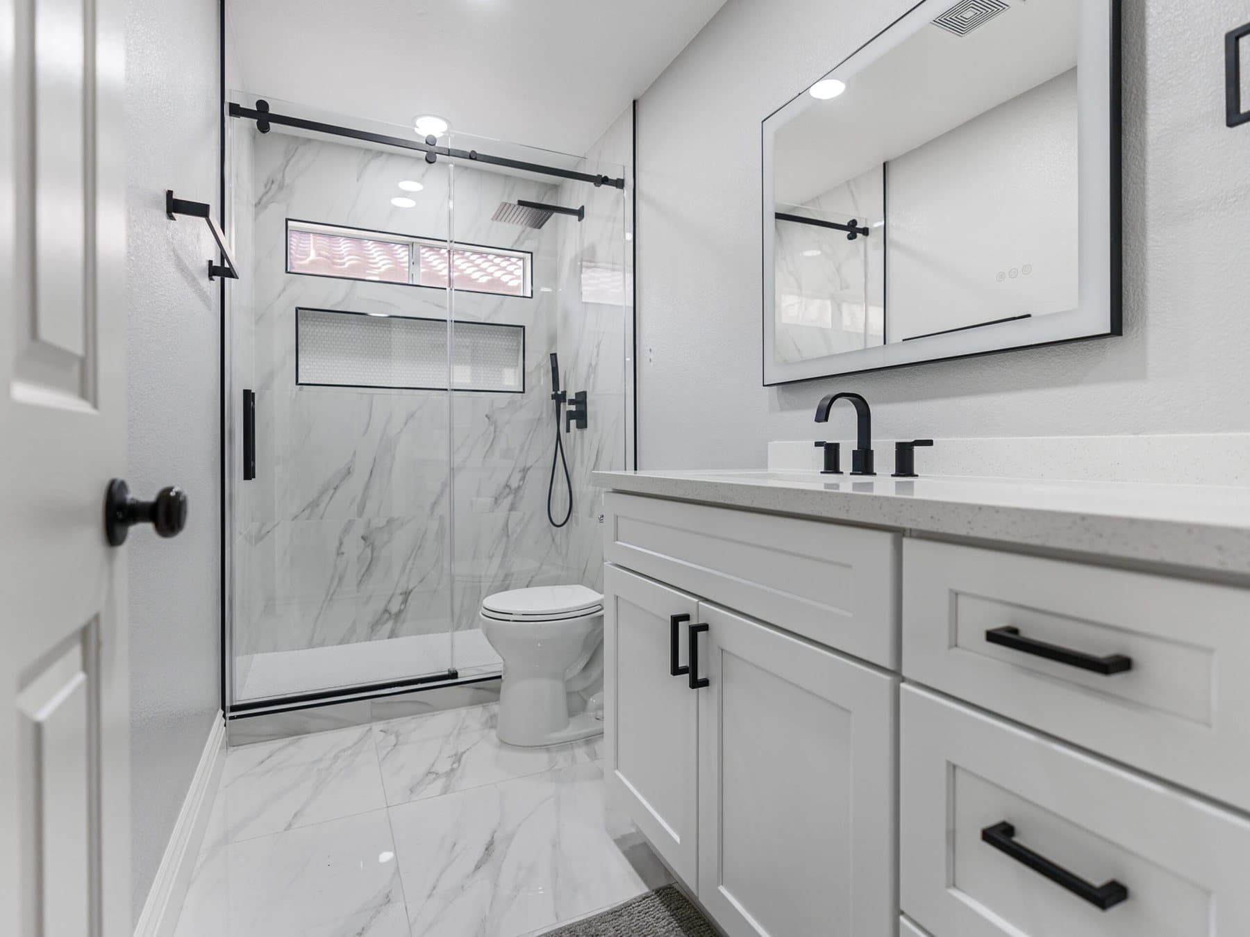 Summerlin bathroom remodel: vanity with black-framed mirror and glass shower