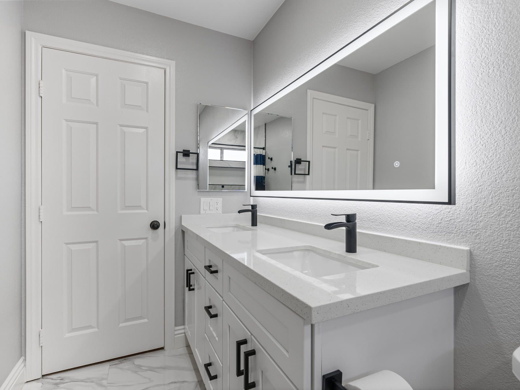 Summerlin bathroom remodel: vanity with illuminated mirror and matte-black faucet