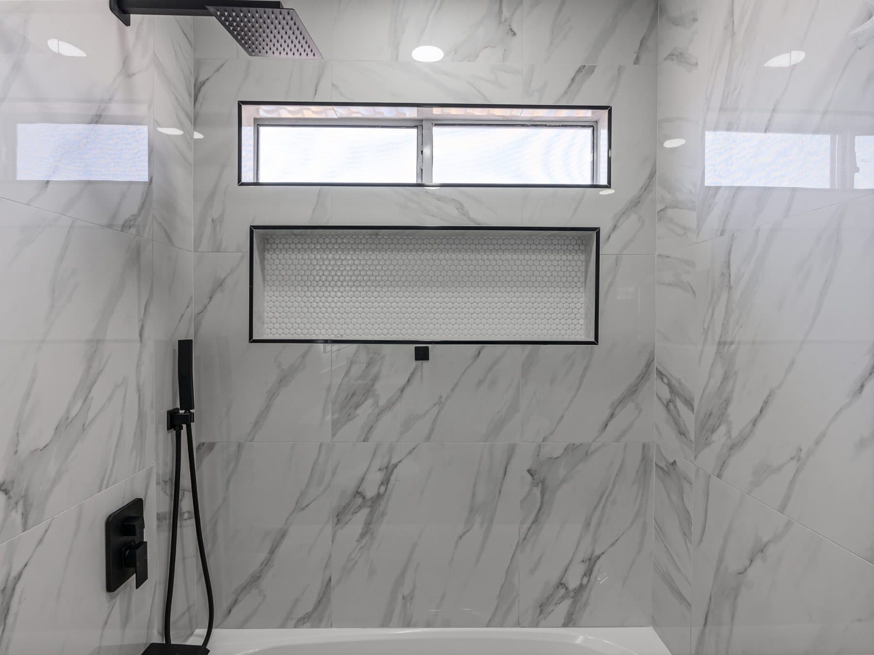 Summerlin bathroom remodel: shower wall with built-in niche and matte-black fixtures