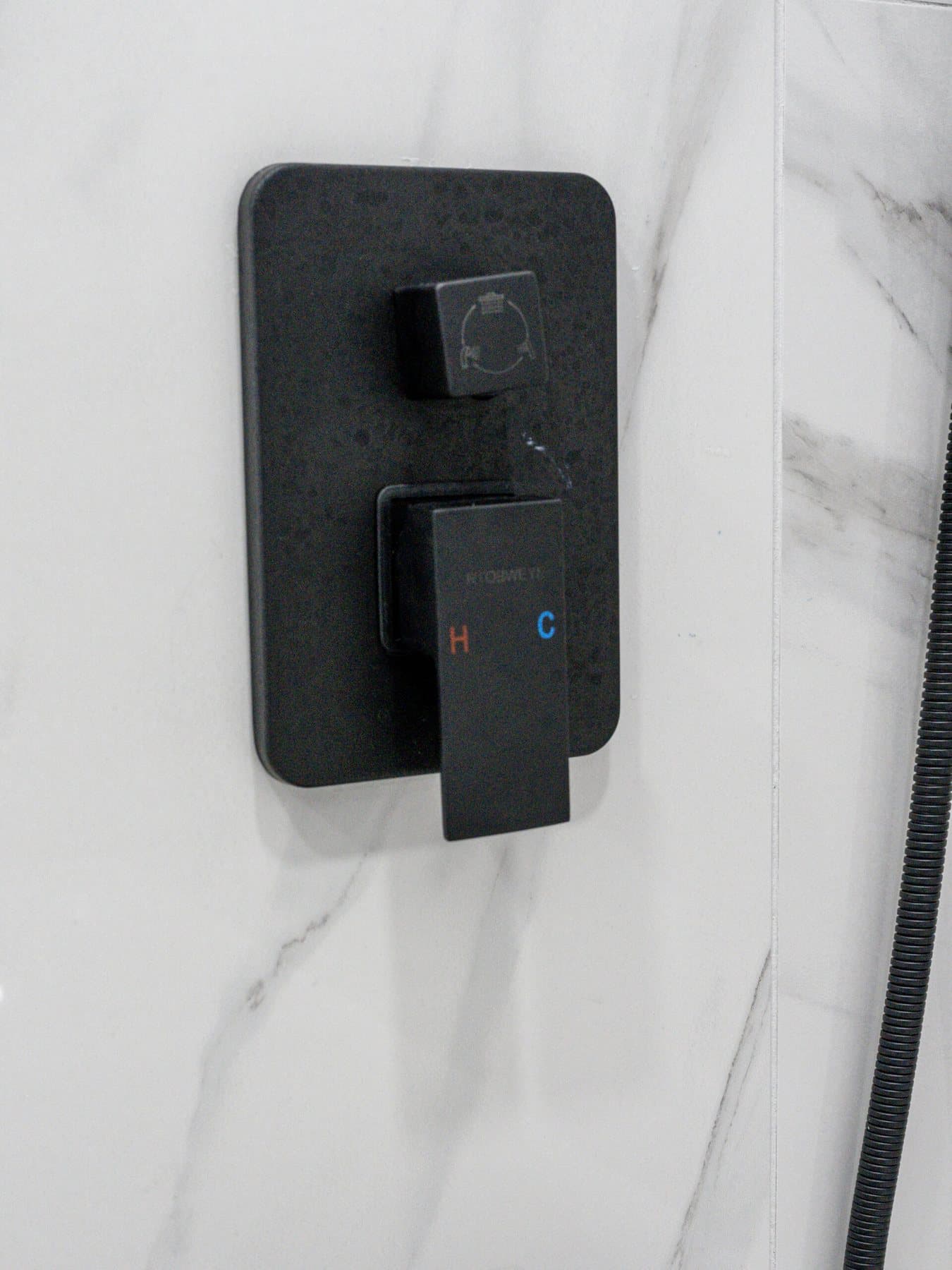 Summerlin bathroom remodel: matte-black shower valve on marble-look tile